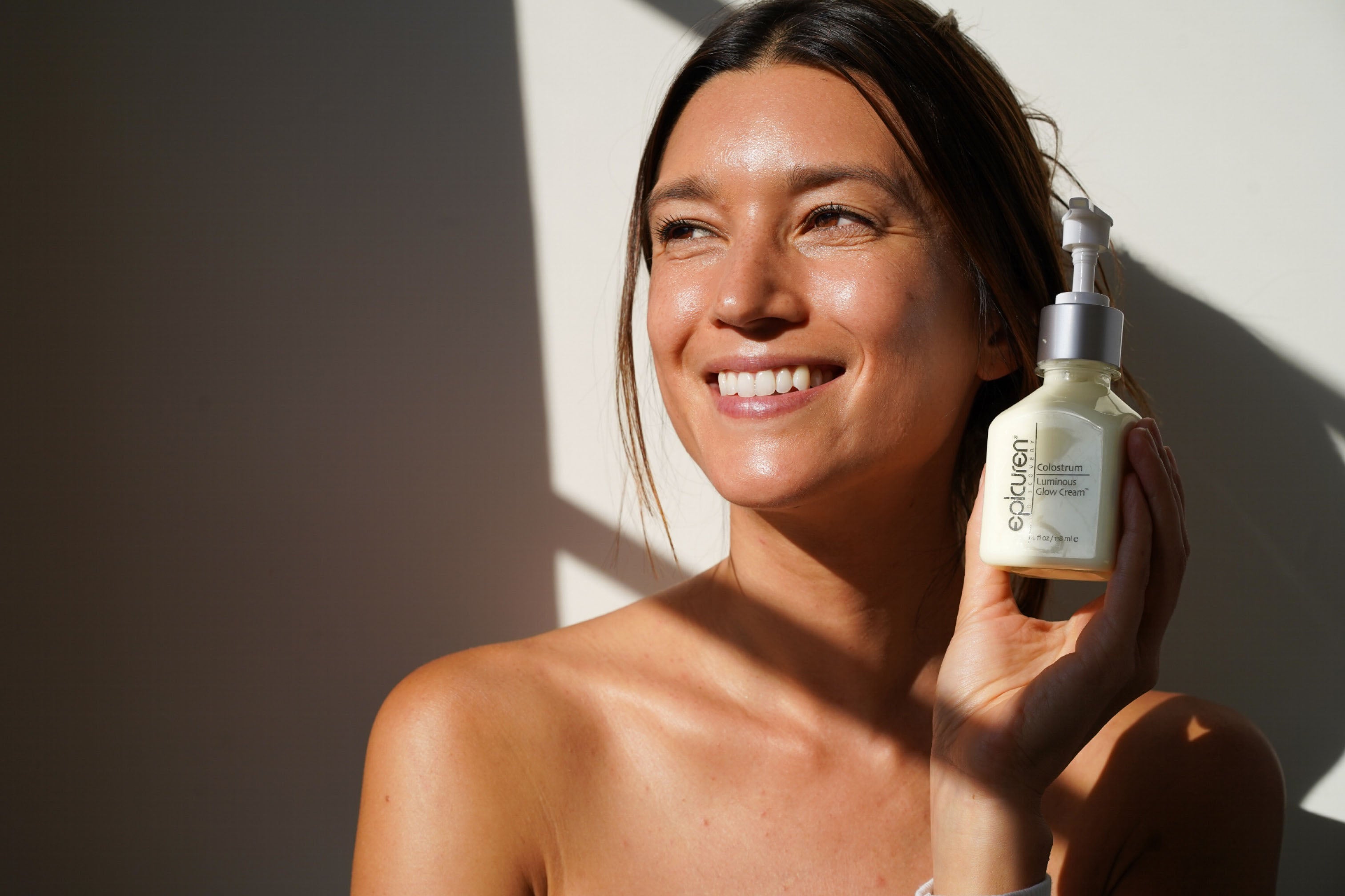 Beautiful woman holding a bottle of Colostrum Cream