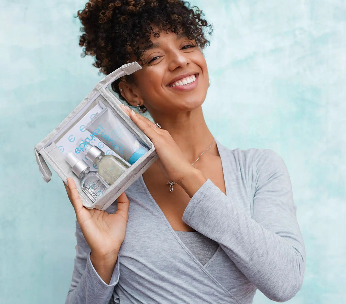 Woman holding Clarify Starter Kit against a light blue background